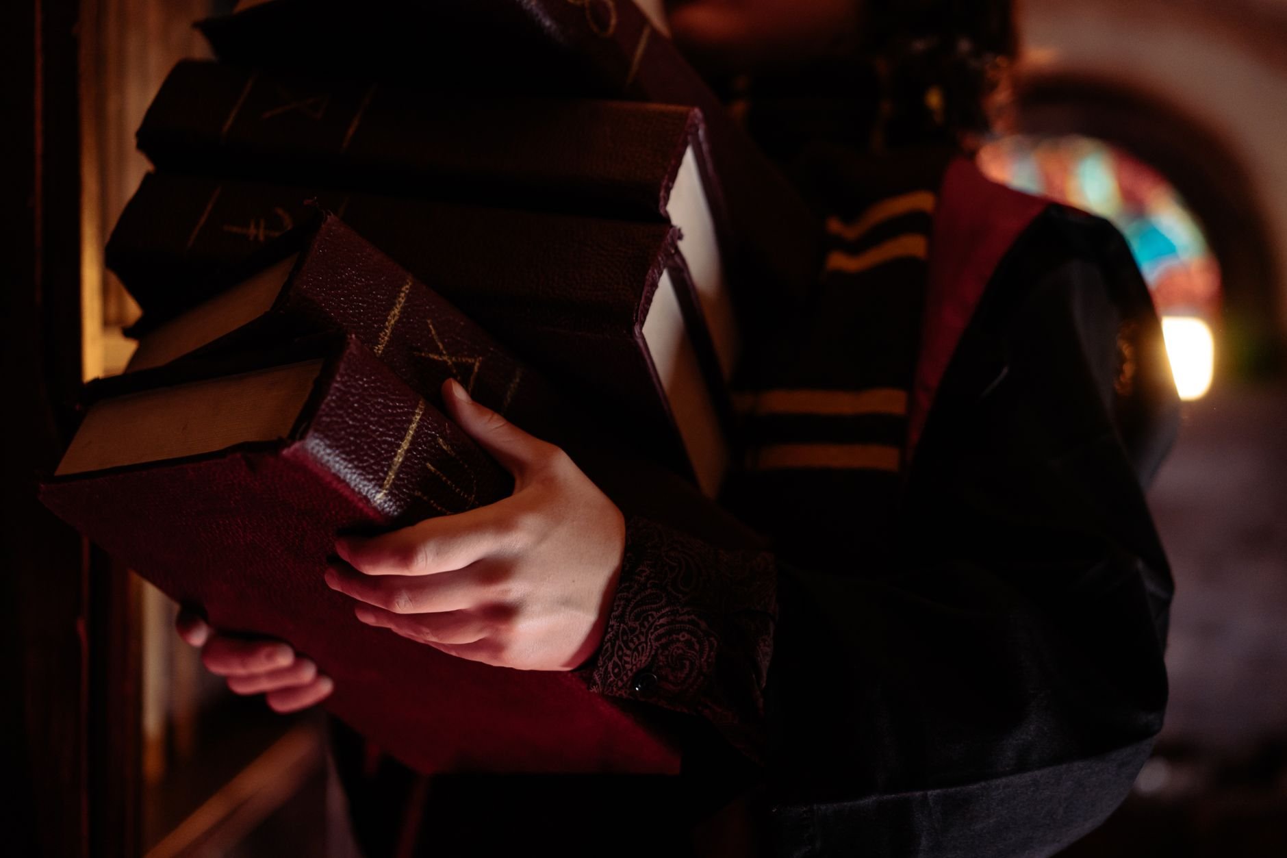 Dimly lit ancient library with stacked old books, evoking scholarly atmosphere